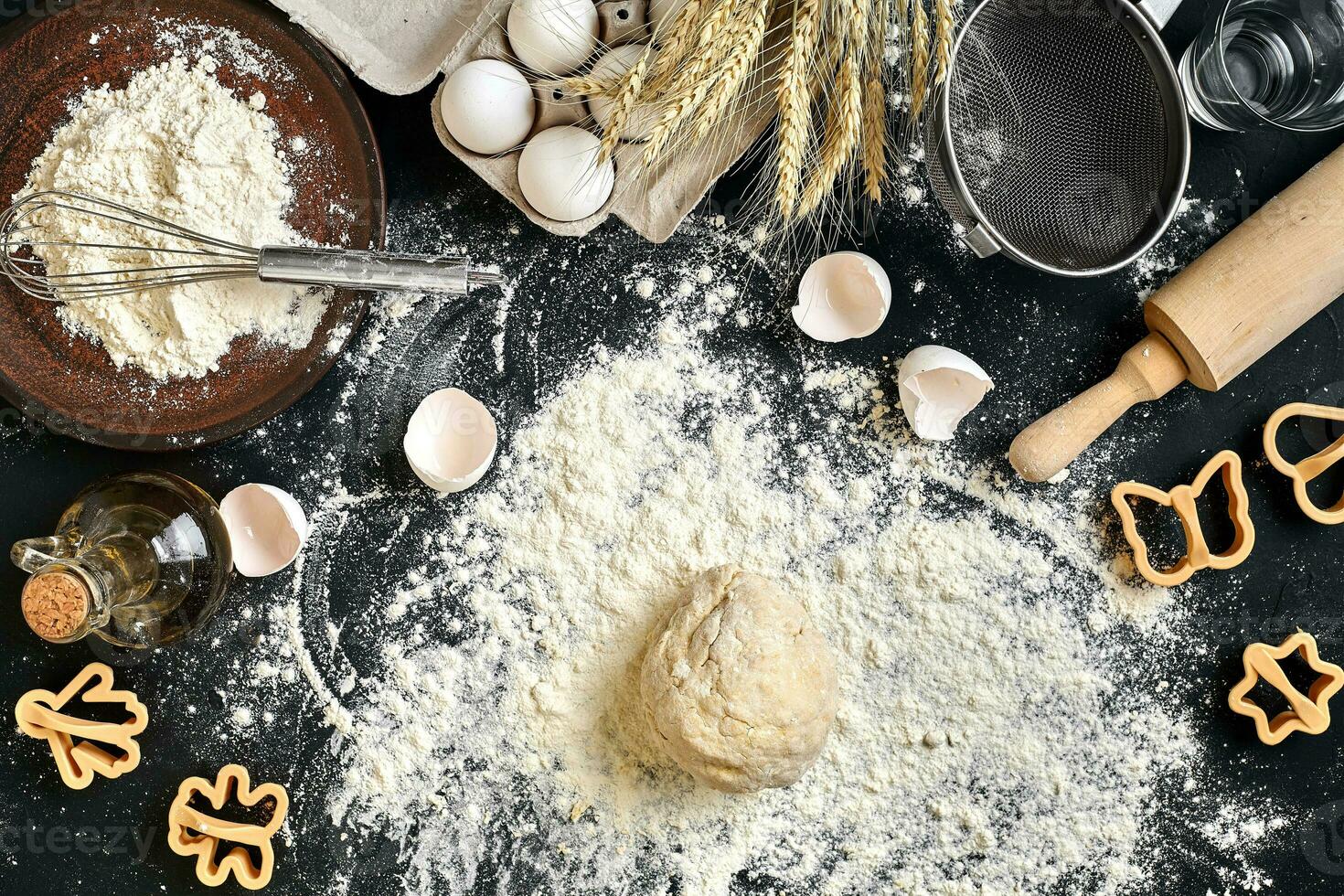 Cooking dough for cookies, butter, eggs, cooking equipment, flour on a black table. Top view with copy space, mockup for menu, recipe or culinary classes. Baking background. photo