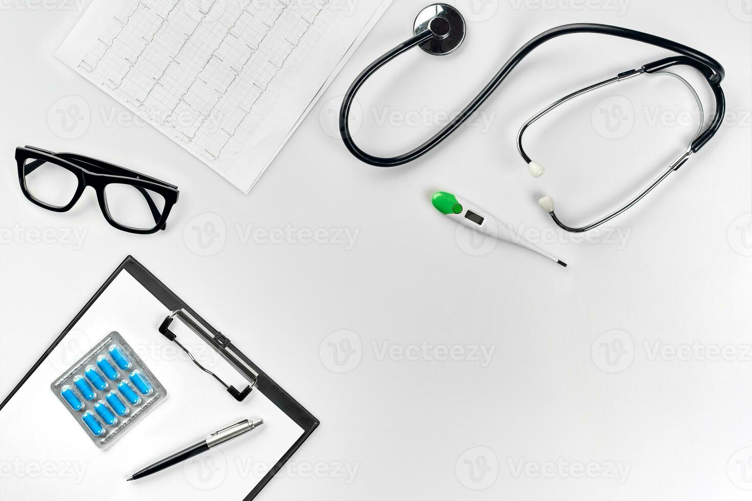Stethoscope in the office of doctors.Top view of doctor's desk table, blank paper on clipboard with pen. Copy space. Designer's blank photo