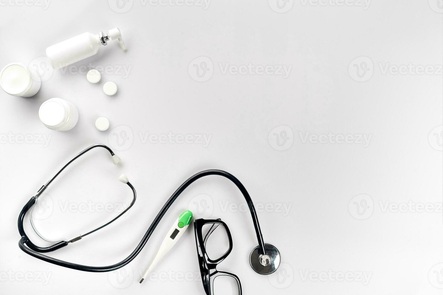 Doctor's office desk with medical documents, charts, eyeglasses and stethoscope. Top view. Copy space photo