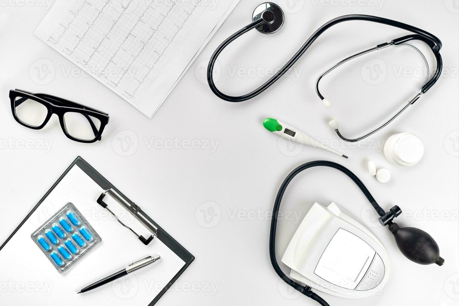 Stethoscope in the office of doctors.Top view of doctor's desk table, blank paper on clipboard with pen. Copy space. Designer's blank photo