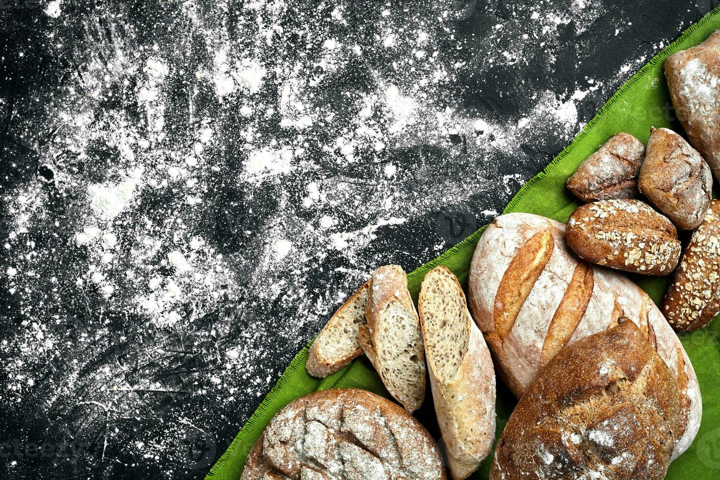 Mixed breads on black table. Top view with copy space. photo