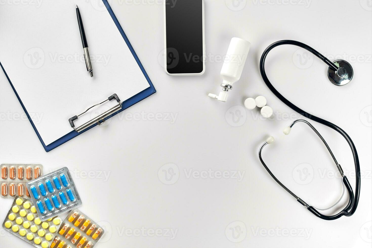 Stethoscope in the office of doctors.Top view of doctor's desk table, blank paper on clipboard with pen. Copy space. Designer's blank photo