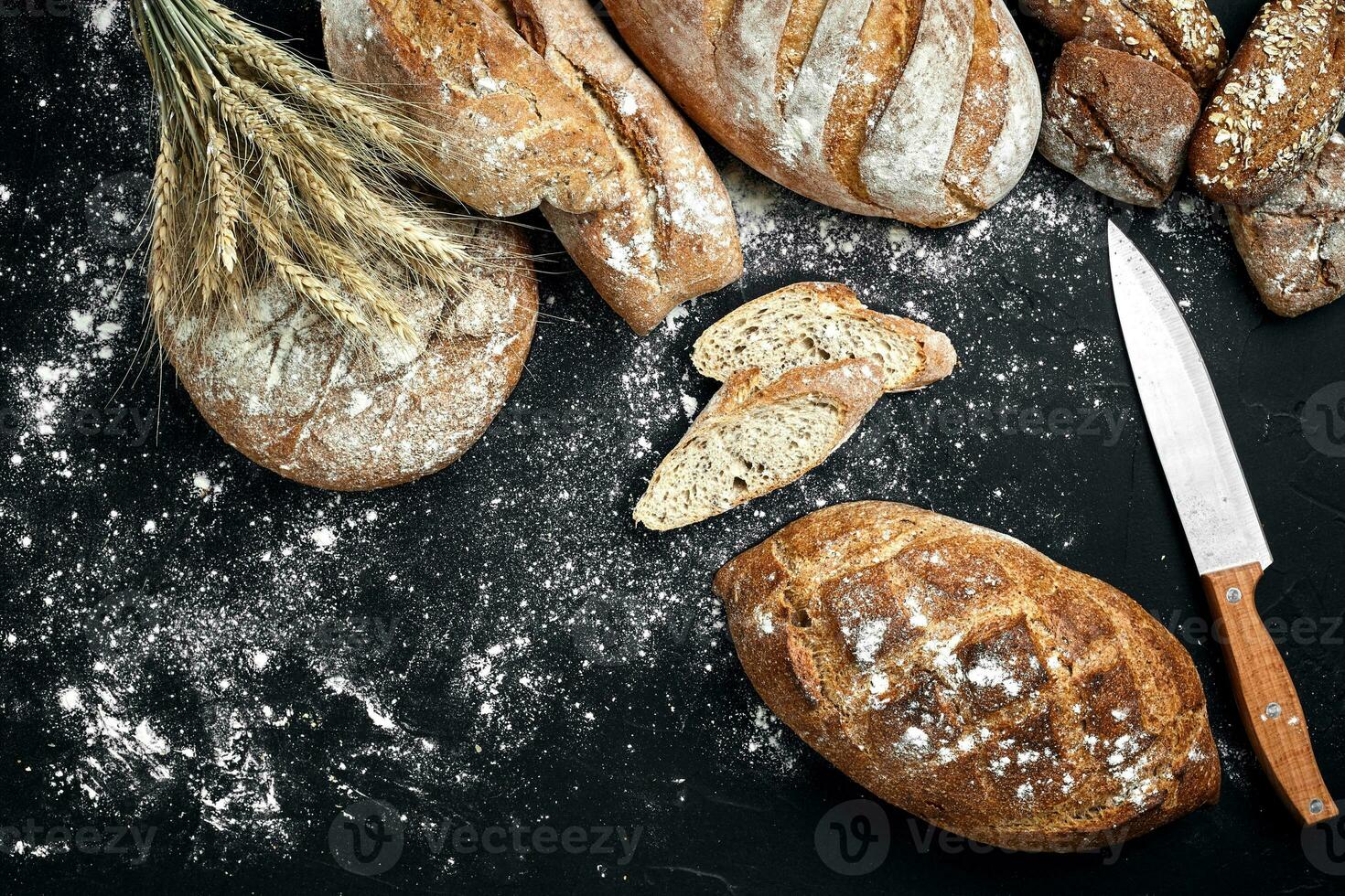 Mixed breads on black table. Top view with copy space. photo