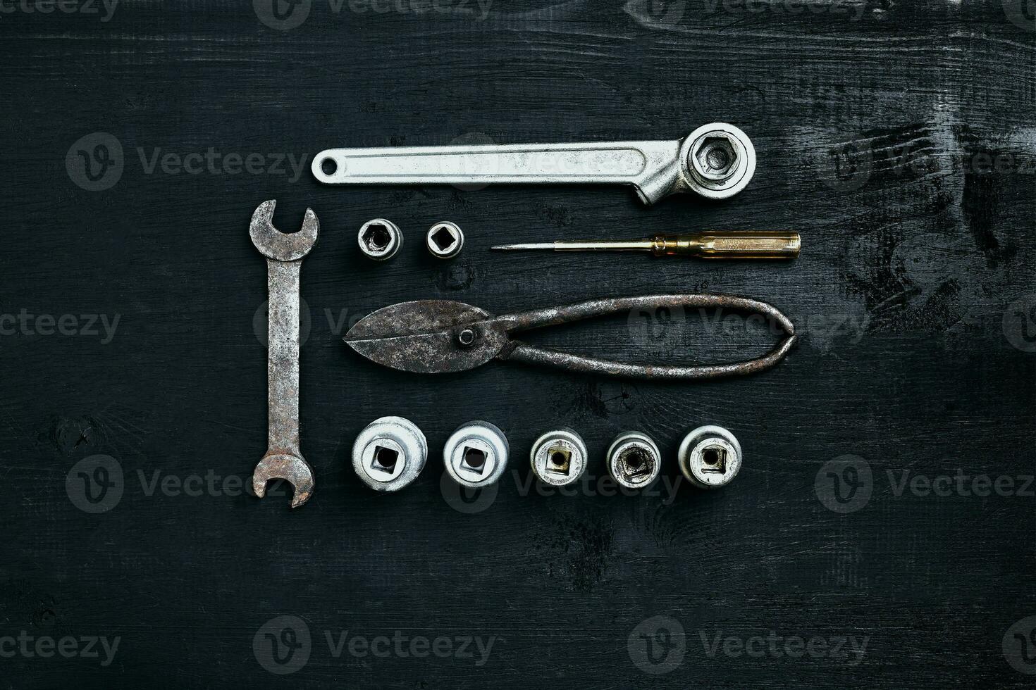 Copy space of working tools on a black wooden surface. Nippers, wrench keys, pliers, screwdriver. Top view. photo