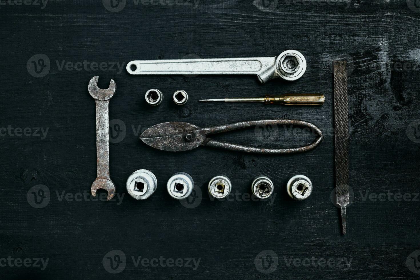 Copy space of working tools on a black wooden surface. Nippers, wrench keys, pliers, screwdriver. Top view. photo