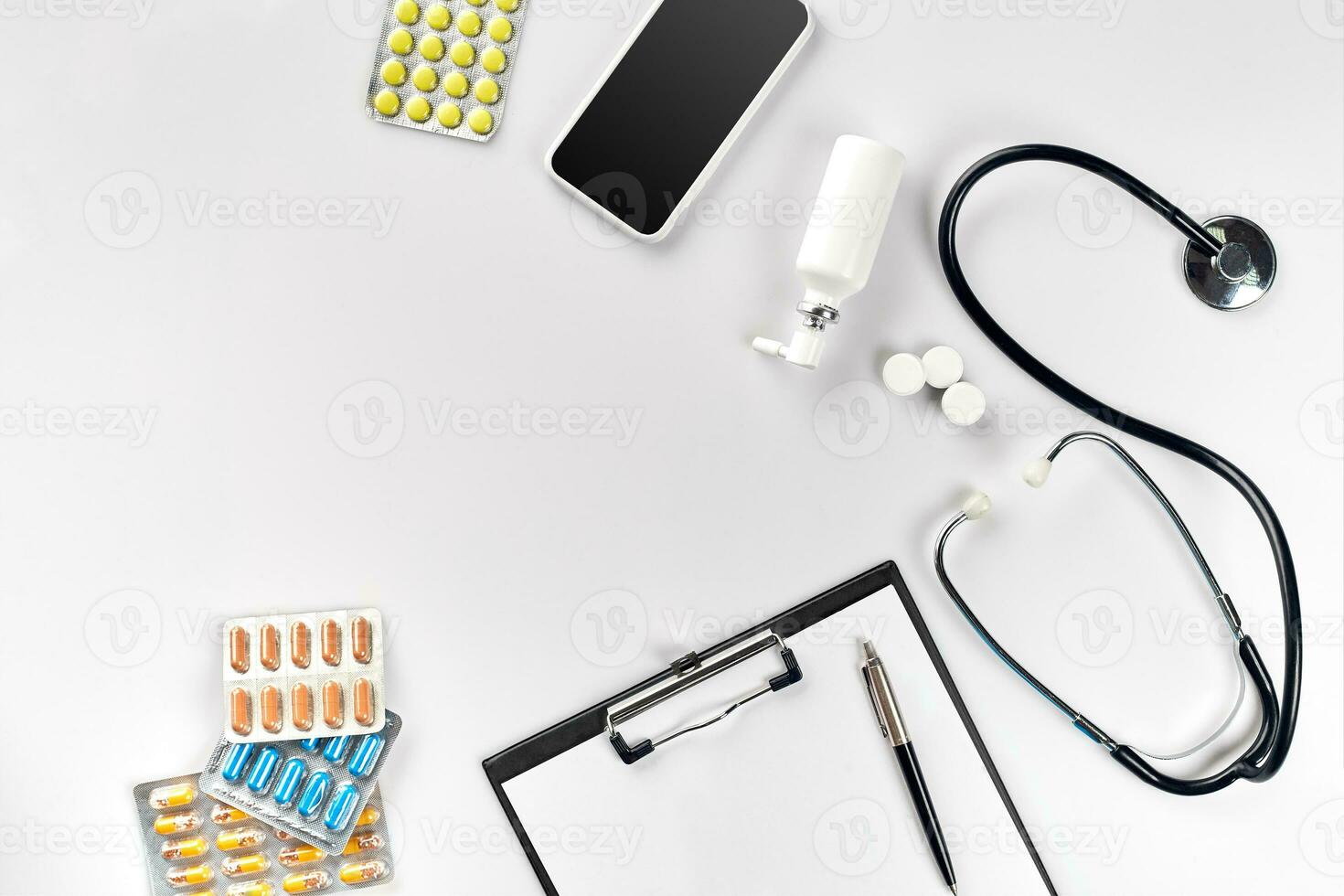 Stethoscope in the office of doctors.Top view of doctor's desk table, blank paper on clipboard with pen. Copy space. Designer's blank photo