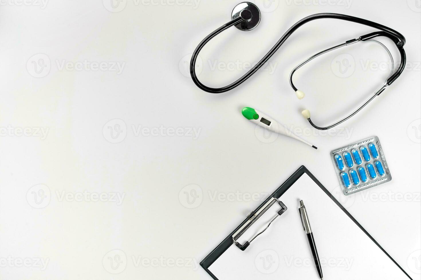 Stethoscope in the office of doctors.Top view of doctor's desk table, blank paper on clipboard with pen. Copy space. Designer's blank photo