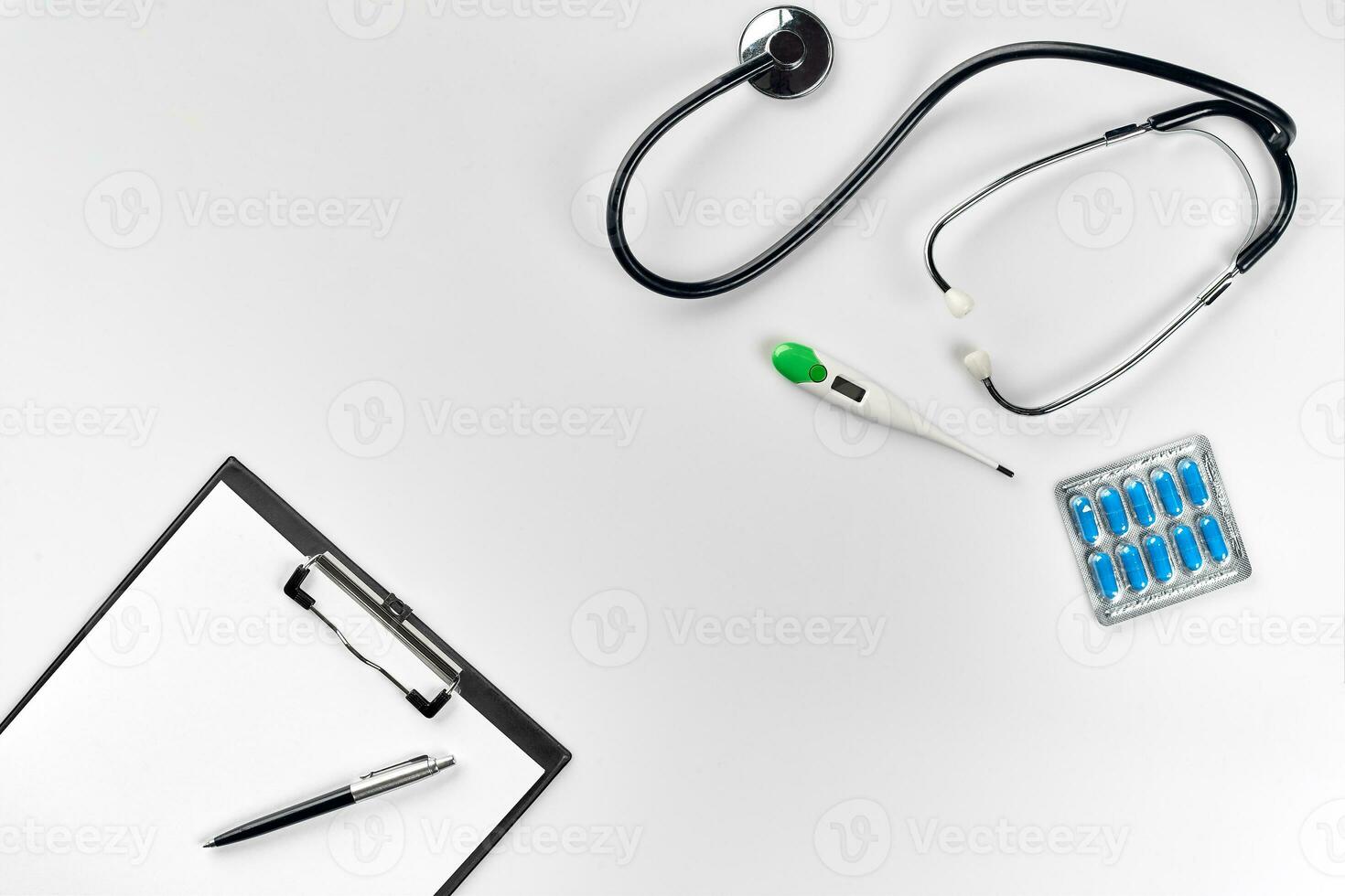 Stethoscope in the office of doctors.Top view of doctor's desk table, blank paper on clipboard with pen. Copy space. Designer's blank photo