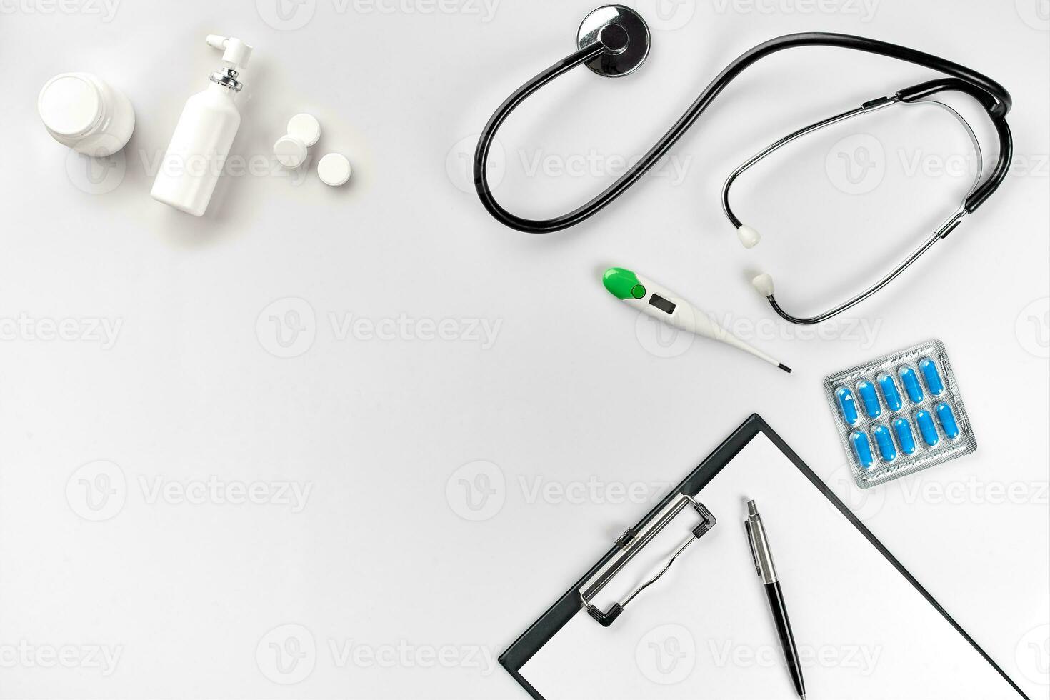 Stethoscope in the office of doctors.Top view of doctor's desk table, blank paper on clipboard with pen. Copy space. Designer's blank photo