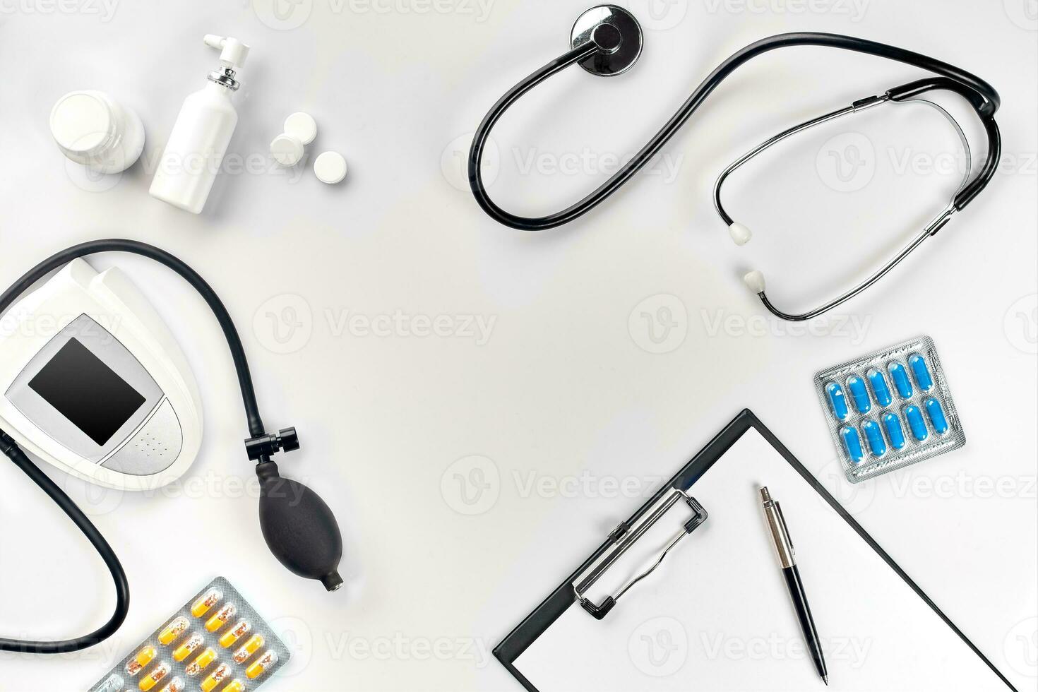 Stethoscope in the office of doctors.Top view of doctor's desk table, blank paper on clipboard with pen. Copy space. Designer's blank photo