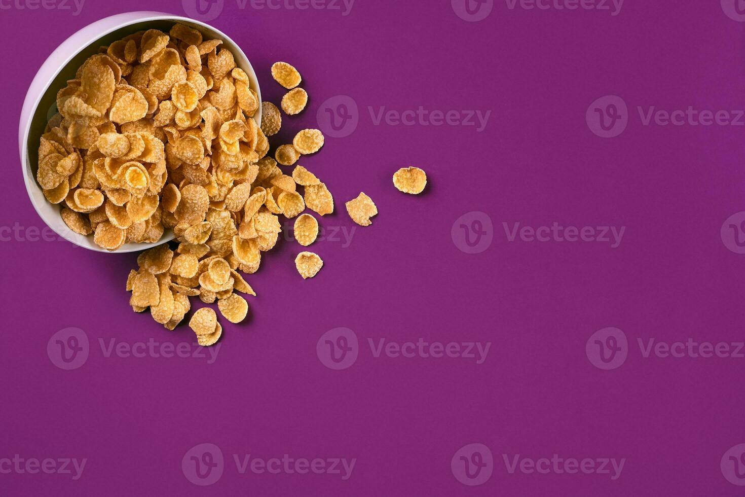 Bowl with cornflakes on the colorful background photo