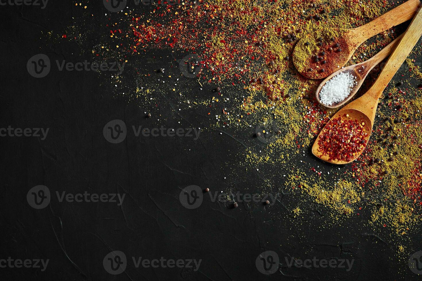 Set of indian spices on black background - green cardamom, turmeric powder, coriander seeds, cumin, and chili, top view photo