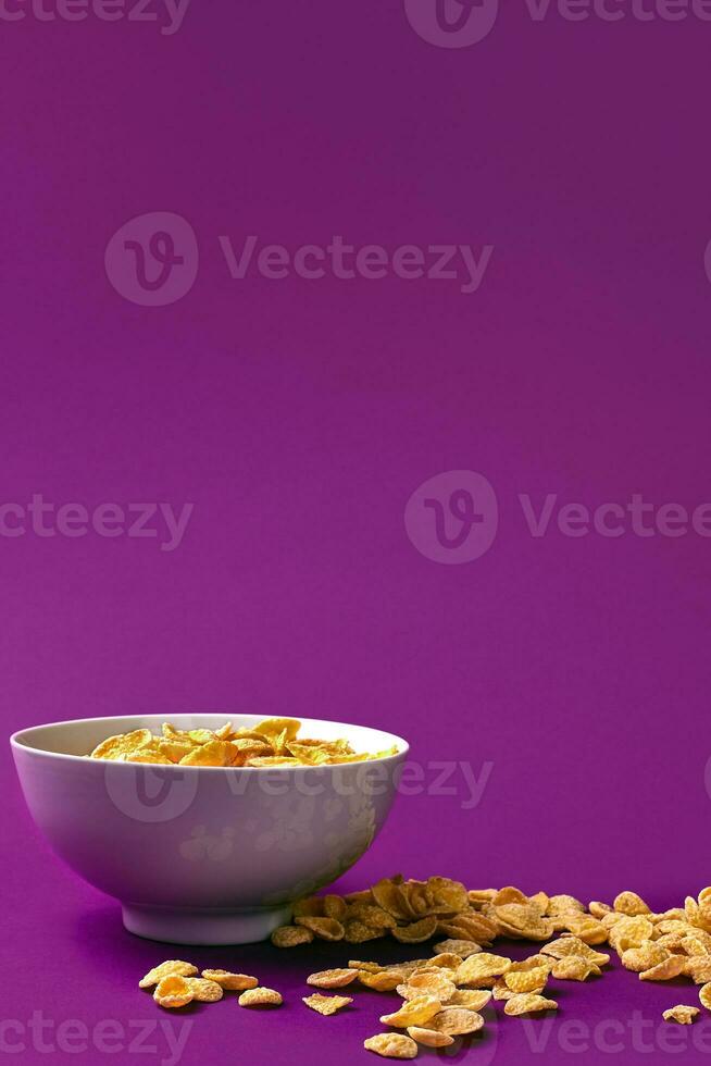 Bowl with cornflakes on the colorful background photo