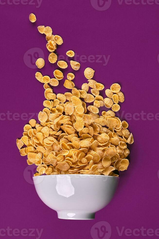 Bowl with cornflakes on the colorful background photo