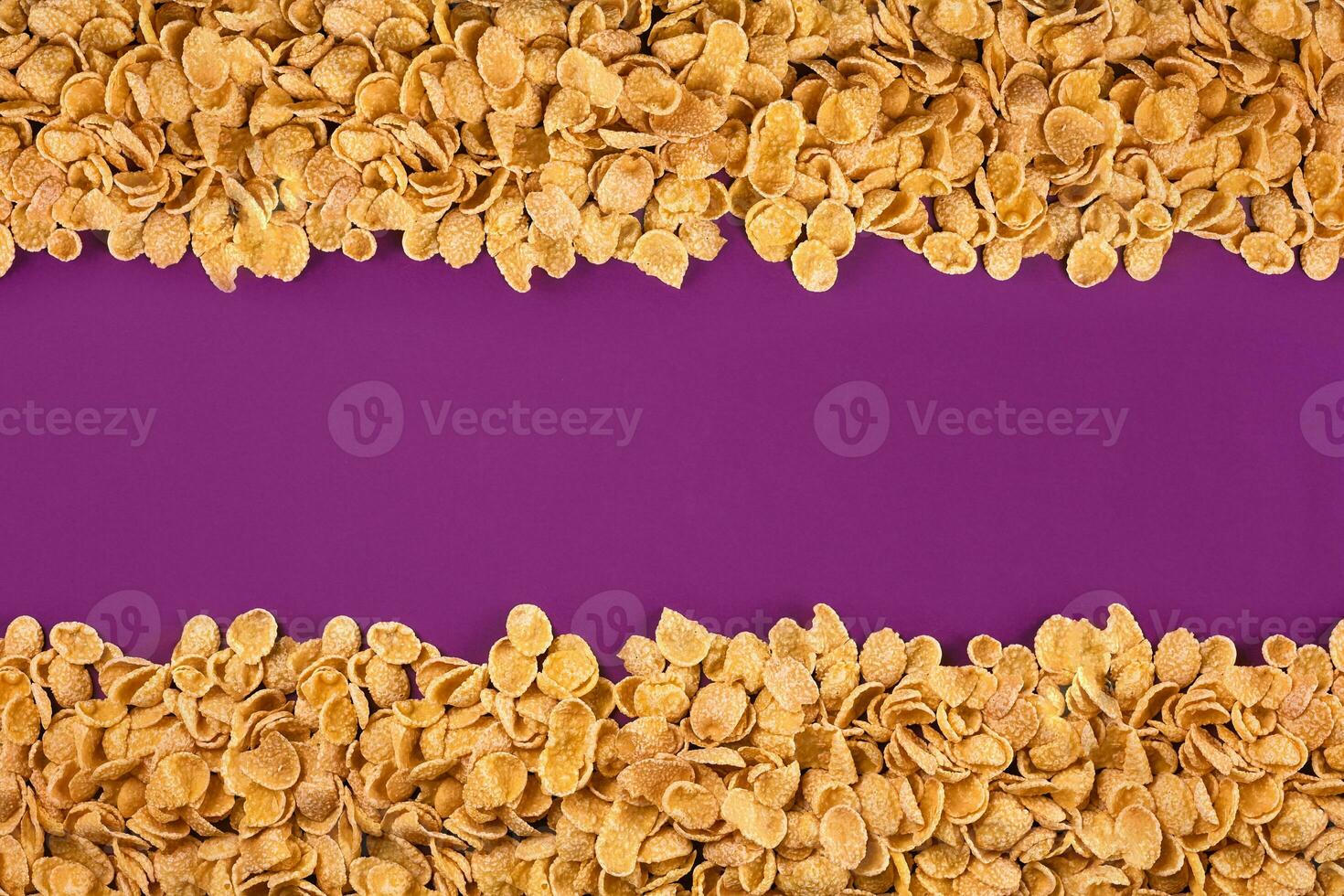 A frame lined with corn flakes. Cornflakes scattered on a purple background. Copy space photo