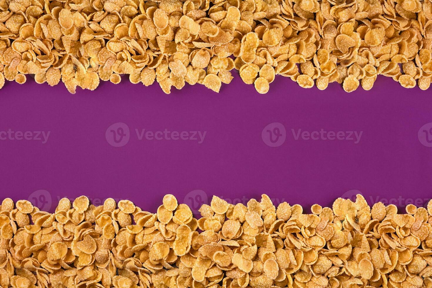 A frame lined with corn flakes. Cornflakes scattered on a purple background. Copy space photo