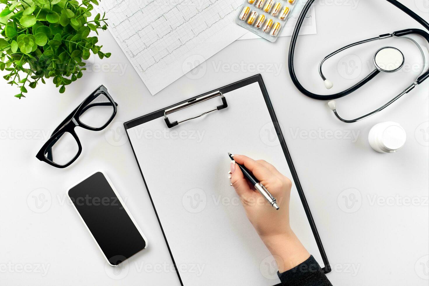 Doctor's work with stethoscope and copybook on hospital desk background. Top view photo
