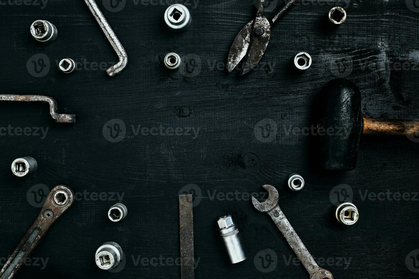 Old, rusty tools lying on a wooden table. Hammer, chisel, metal scissors, wrench, chisel. photo