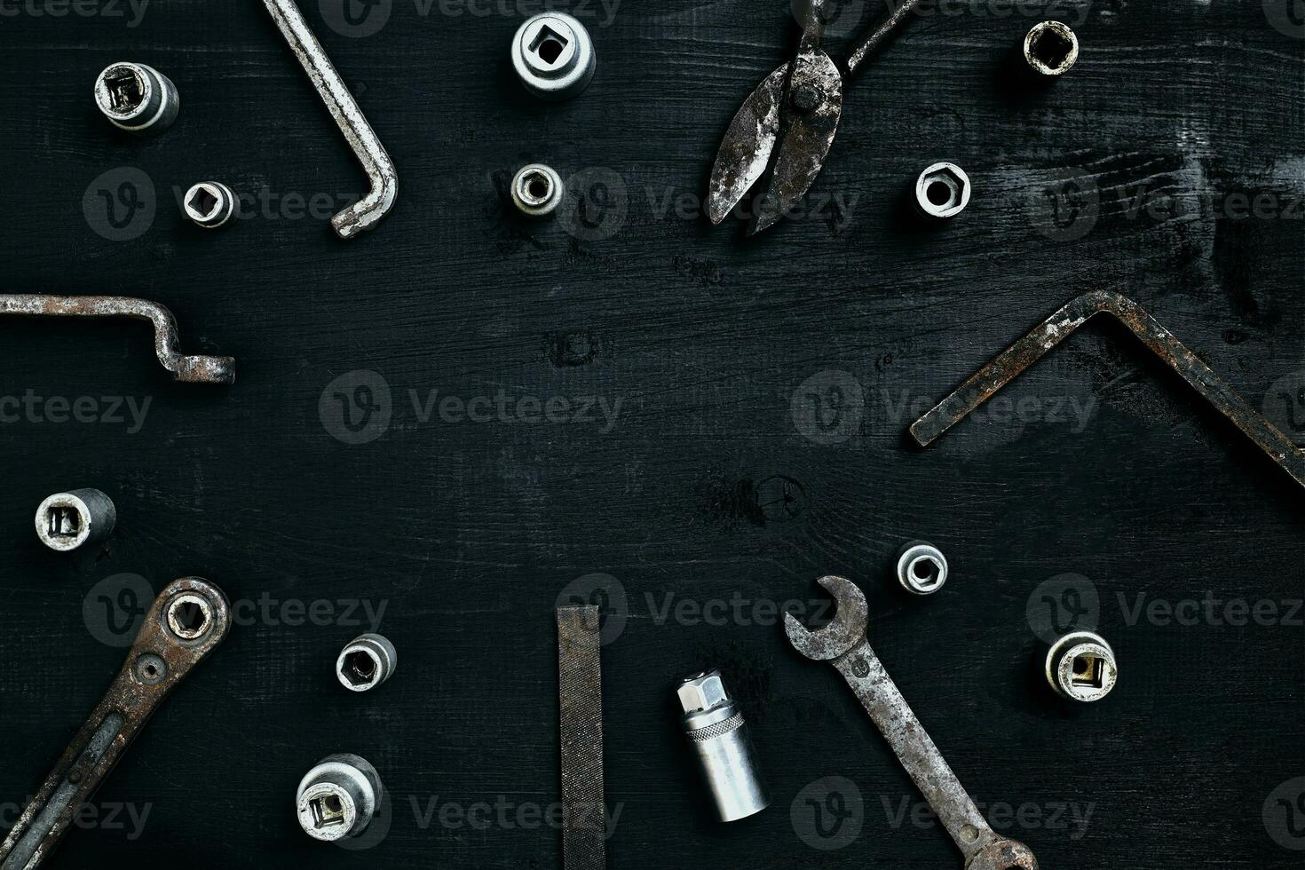 Old, rusty tools lying on a wooden table. Hammer, chisel, metal scissors, wrench, chisel. photo