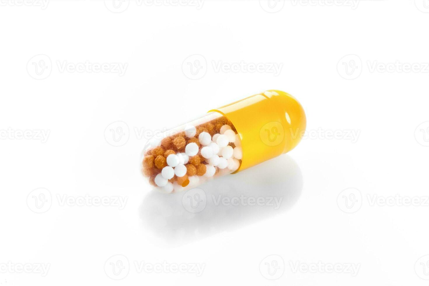 Macro yellow medical pill tablet with pellet, microgranules isolated on white photo