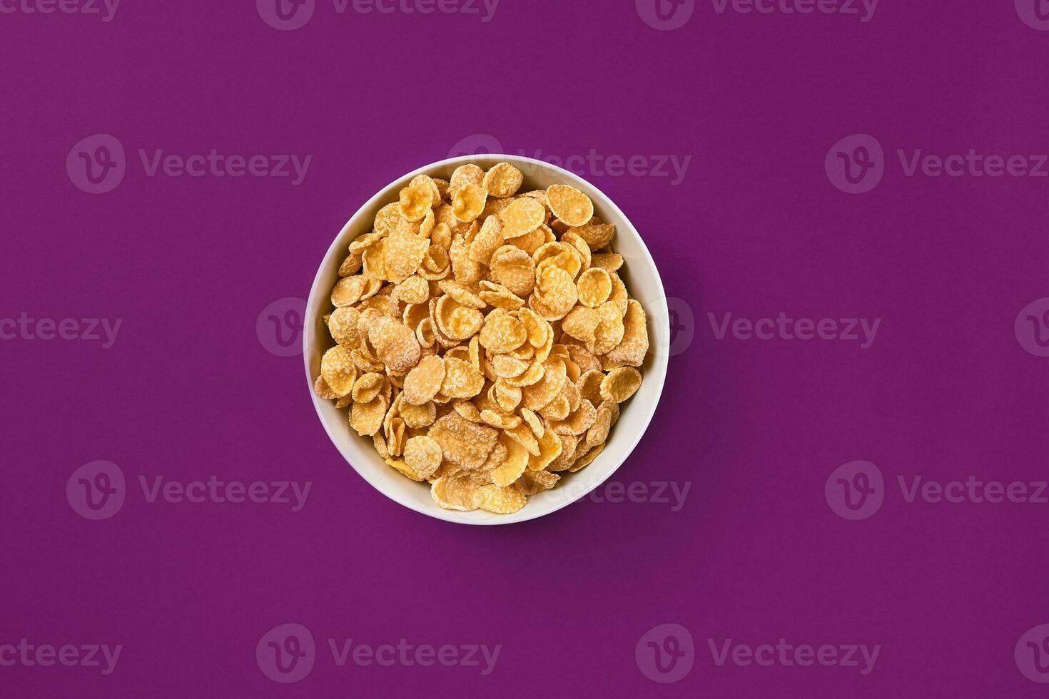 Bowl with cornflakes on the colorful background photo