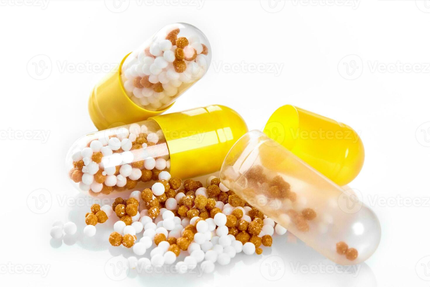 Macro yellow medical pill tablet with pellet, microgranules isolated on white photo