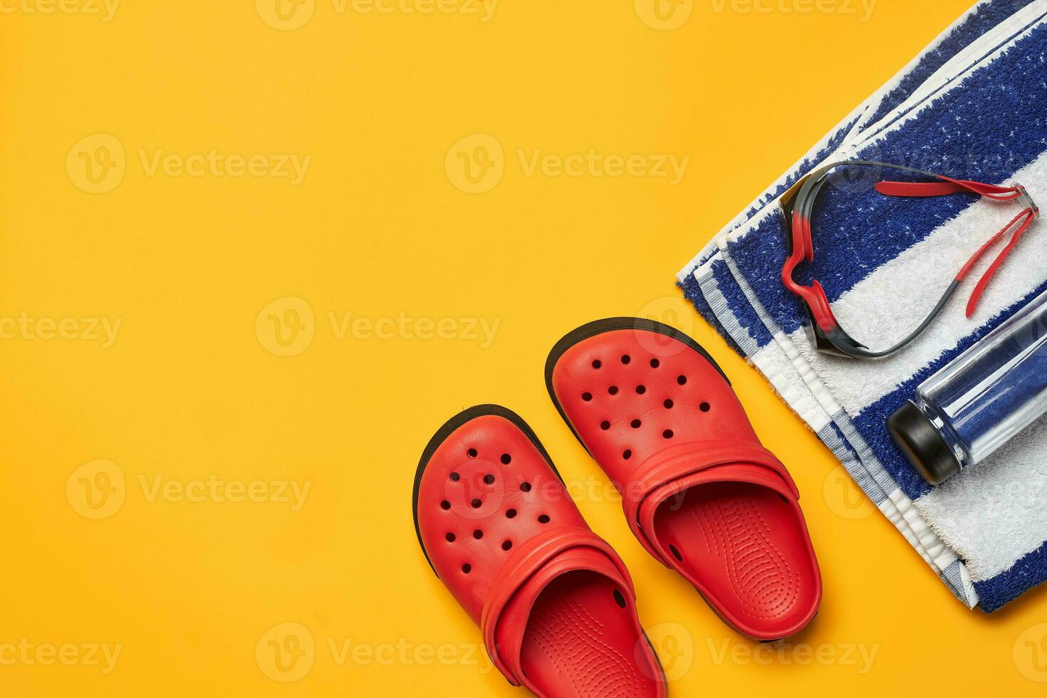 Flat lay summer pool accessories on a yellow background. Colorful beach wear. photo