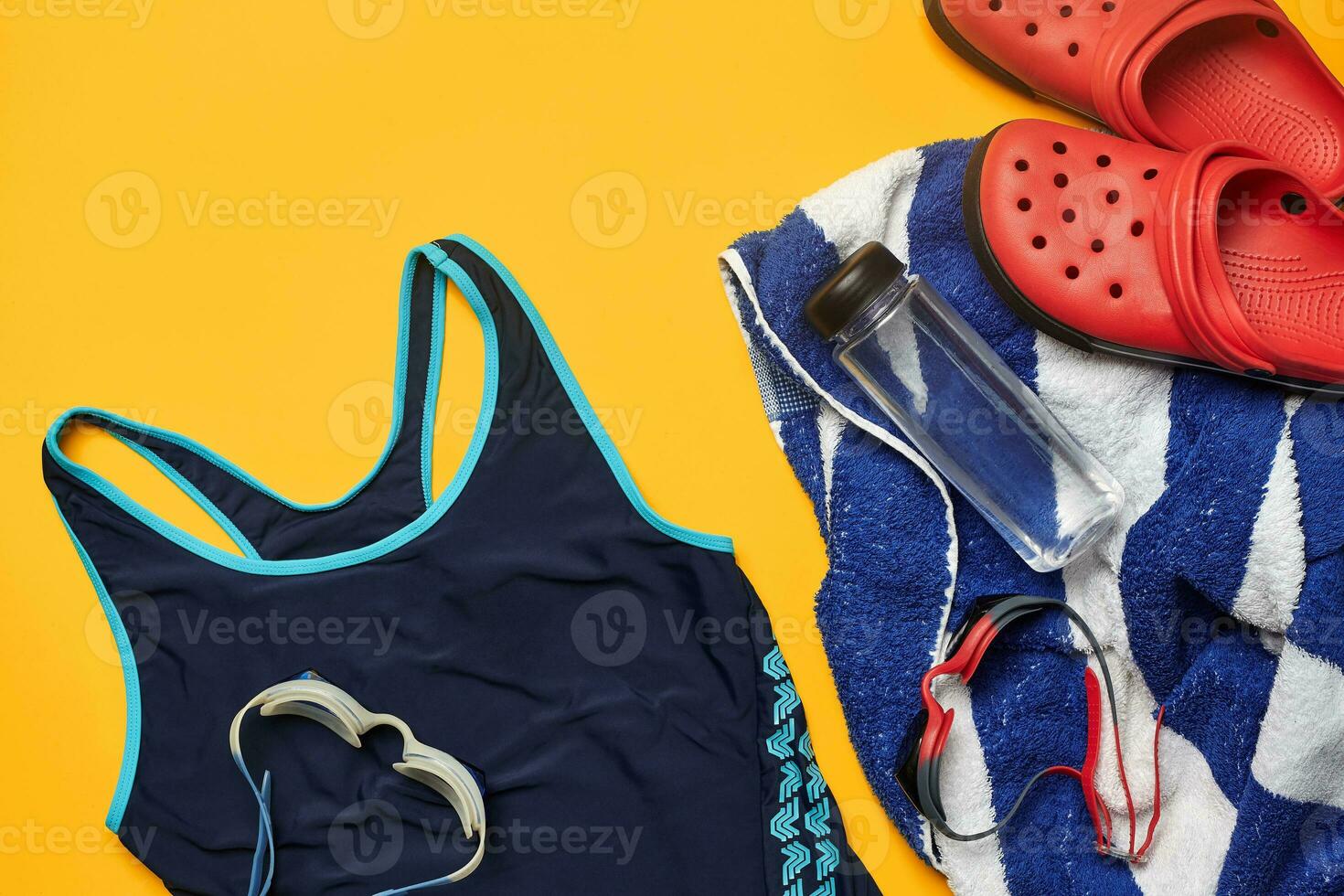 Flat lay summer pool accessories on a yellow background. Colorful beach wear. photo