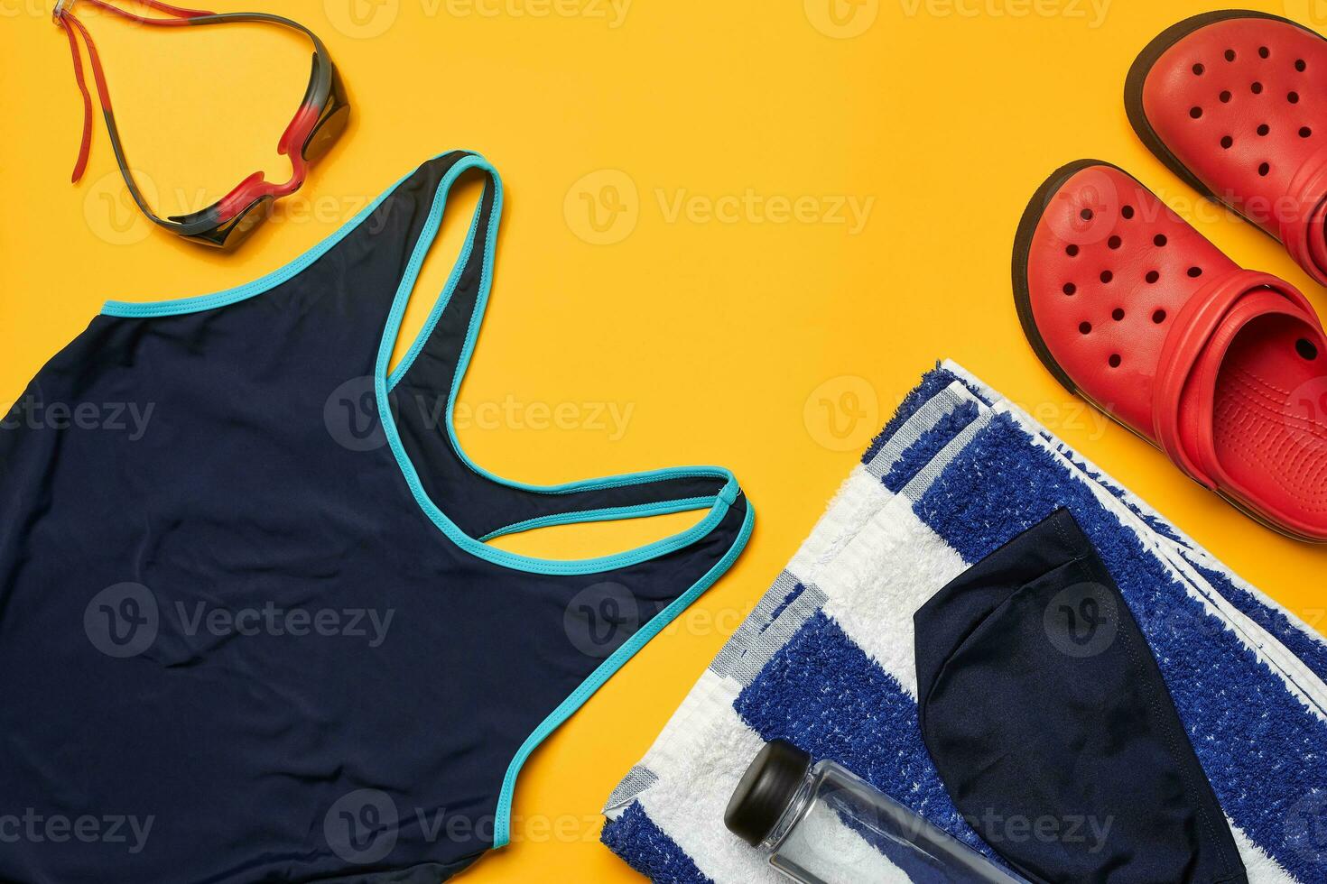 Flat lay summer pool accessories on a yellow background. Colorful beach wear. photo