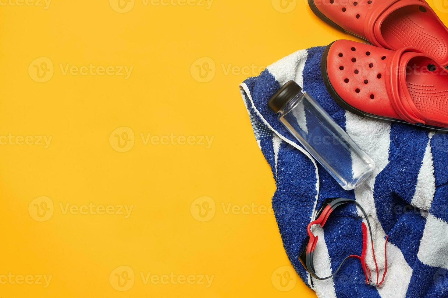 Flat lay summer pool accessories on a yellow background. Colorful beach wear. photo