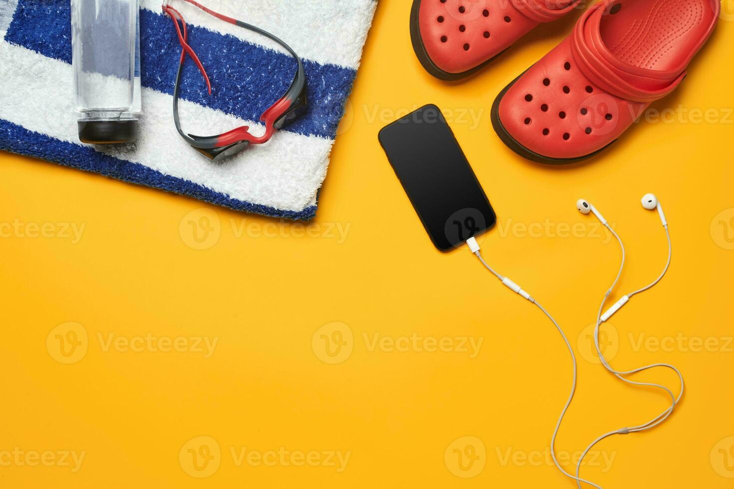 Flat lay summer pool accessories on a yellow background. Colorful beach wear. photo