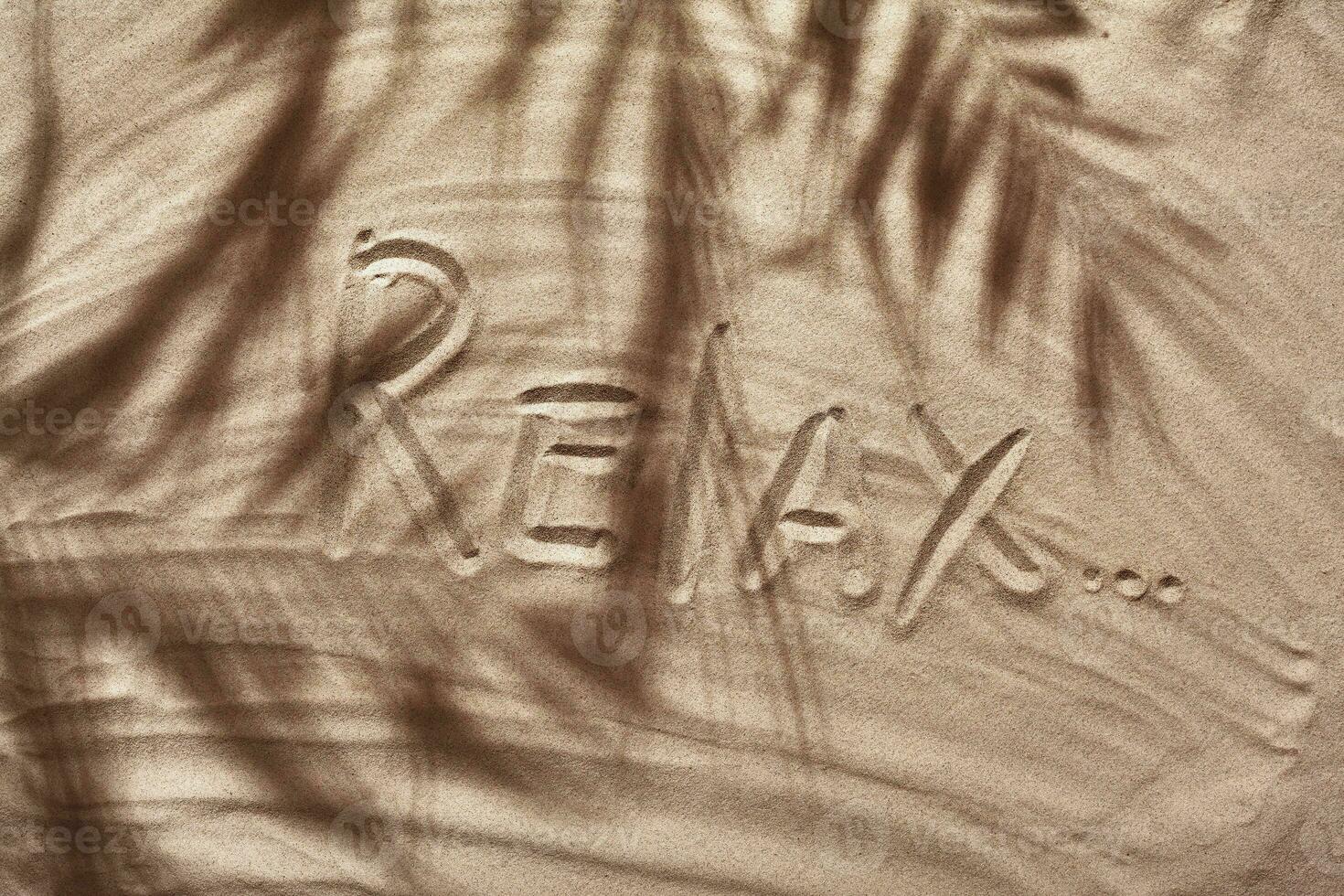 Summer concept with a shadow of a tropical palm tree leaves, copyspace on a white beach sand. photo