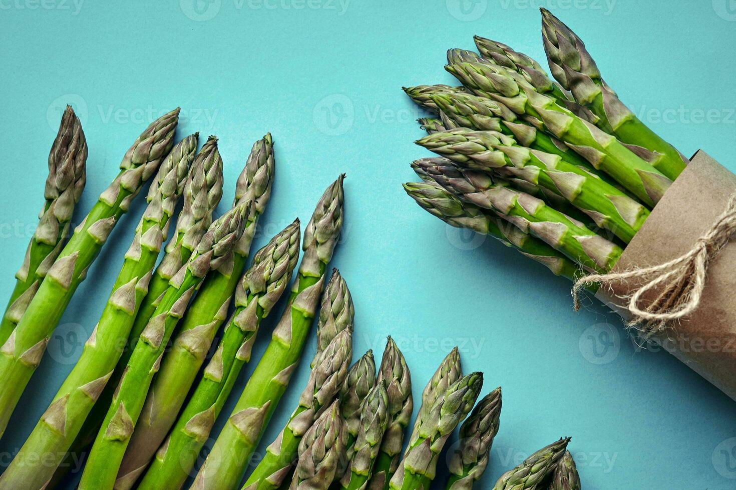 An edible, raw stems of asparagus on blue background. 34241886 Stock