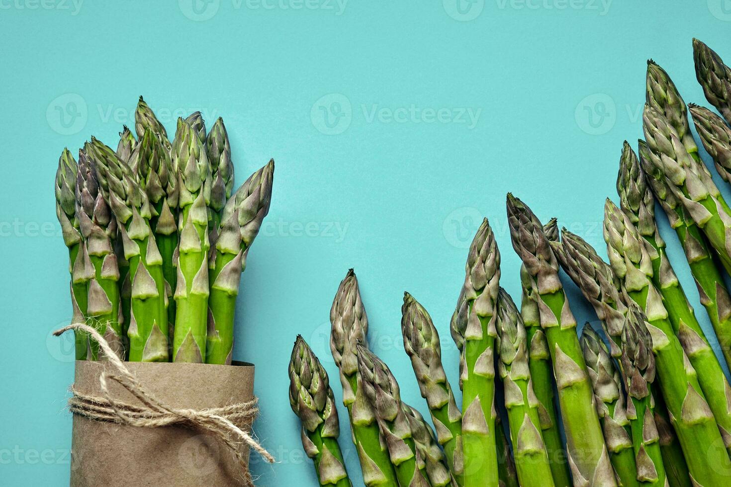 An edible, raw stems of asparagus on blue background. 34241919 Stock