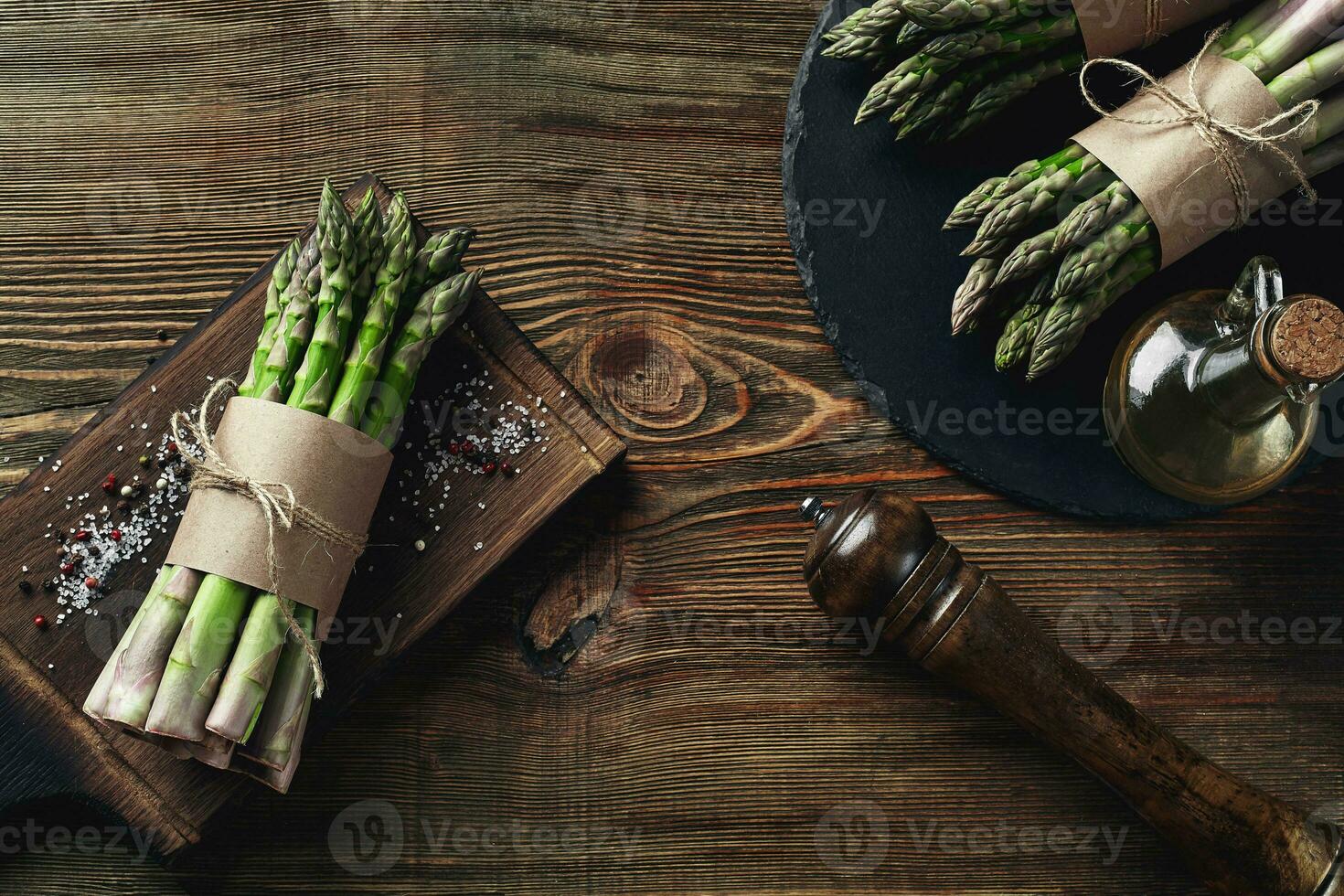 An edible, raw stems of asparagus on a wooden background. photo