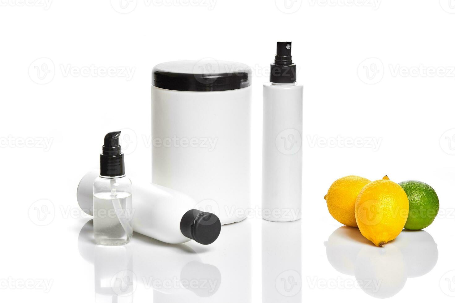 White bottles and two whole lemon and lime isolated on white background. The concept for advertising cosmetics photo