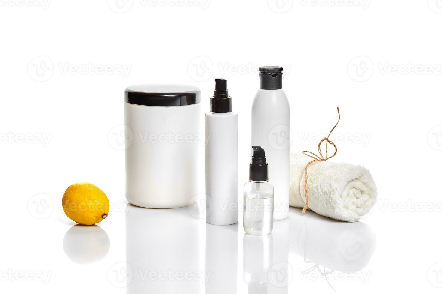 White bottles and one whole lemon isolated on white background. The concept for advertising cosmetics photo