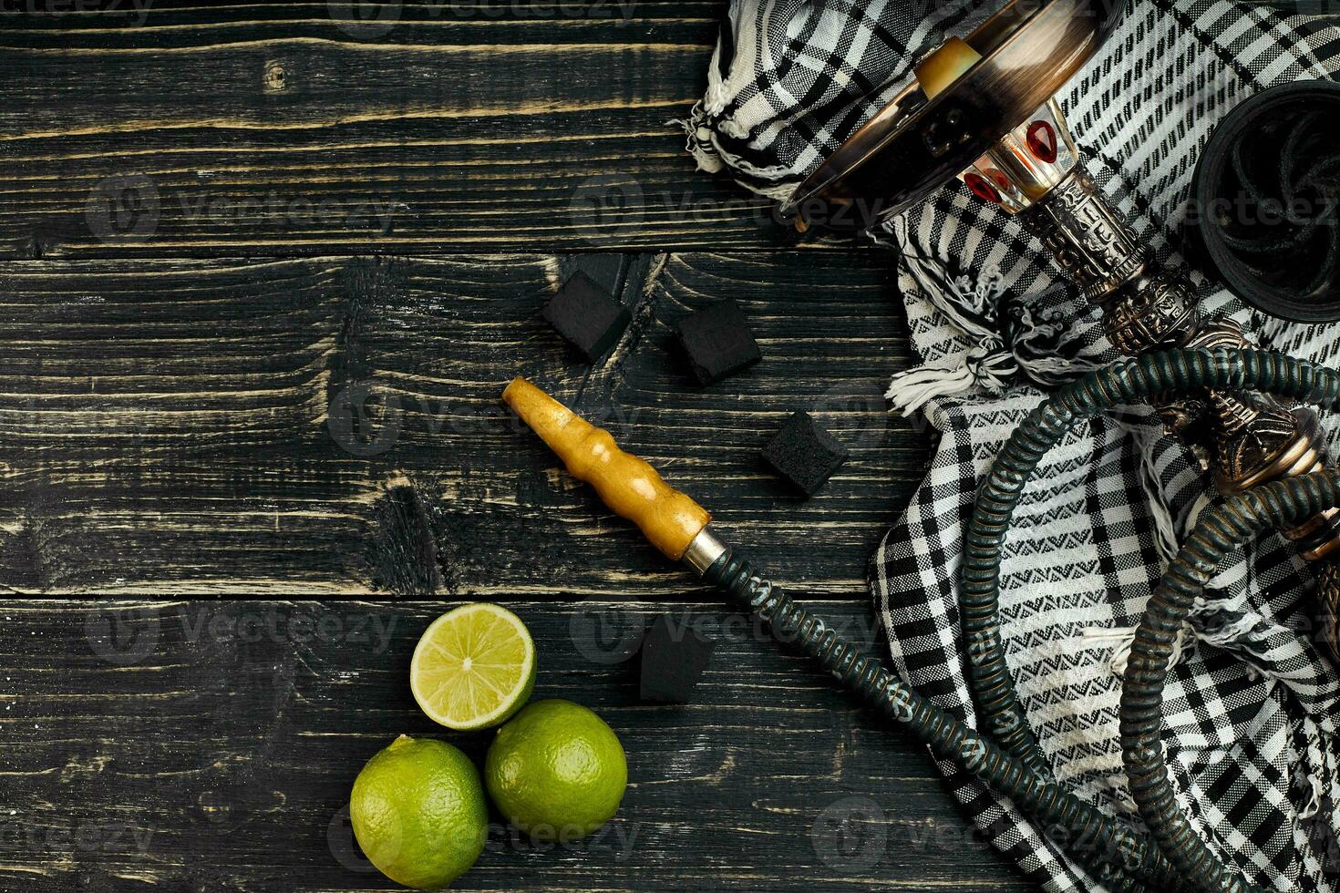 Arabic hookah with a tobacco flavor of a mixture of lime. Top view of a dark wooden background photo