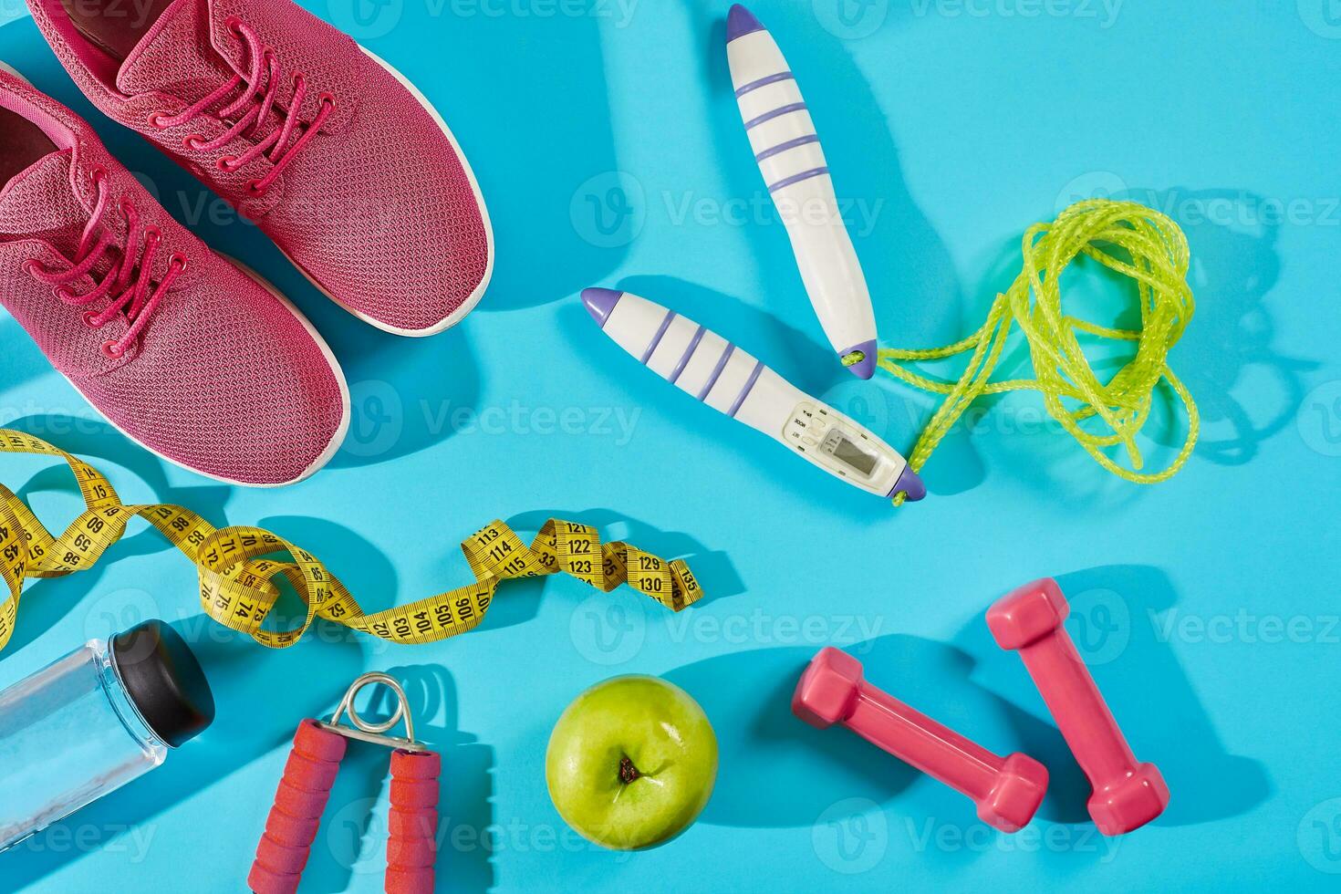 Sneakers with measuring tape on cyan blue background. Sport shoes and sportive equipment for healthy shape. photo
