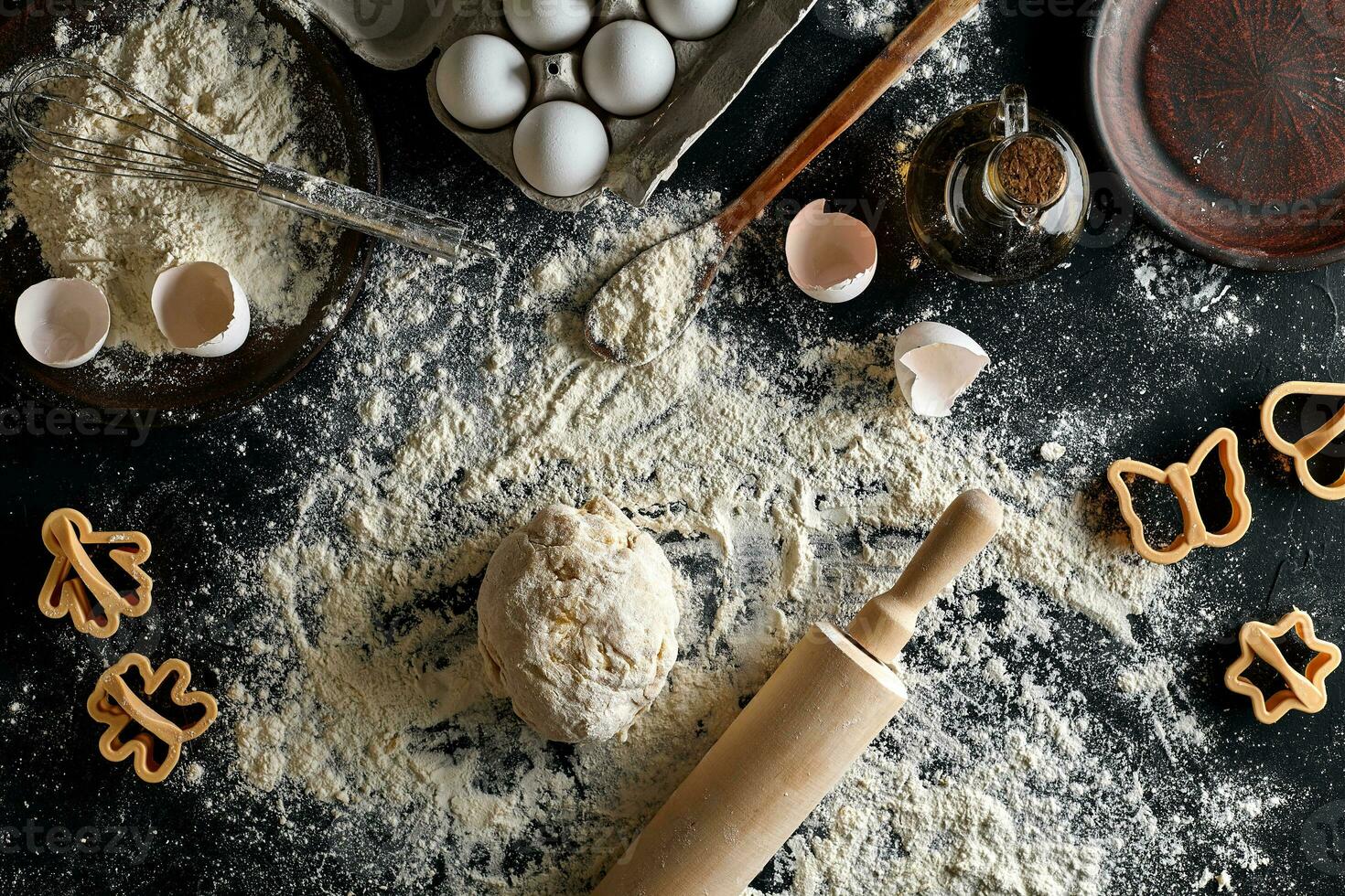 Cooking dough for cookies, butter, eggs, cooking equipment, flour on a black table. Top view with copy space, mockup for menu, recipe or culinary classes. Baking background. photo
