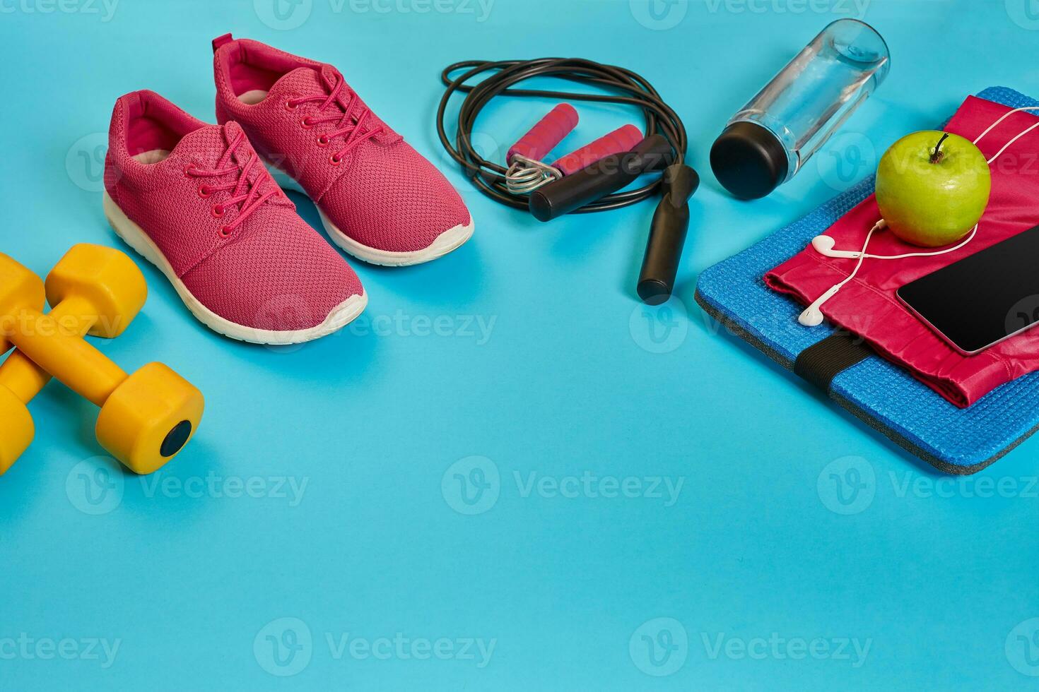 Flat lay of dumbbell, bottle of water, jump rope and sneaker, sport equipments, fitness items, top view photo