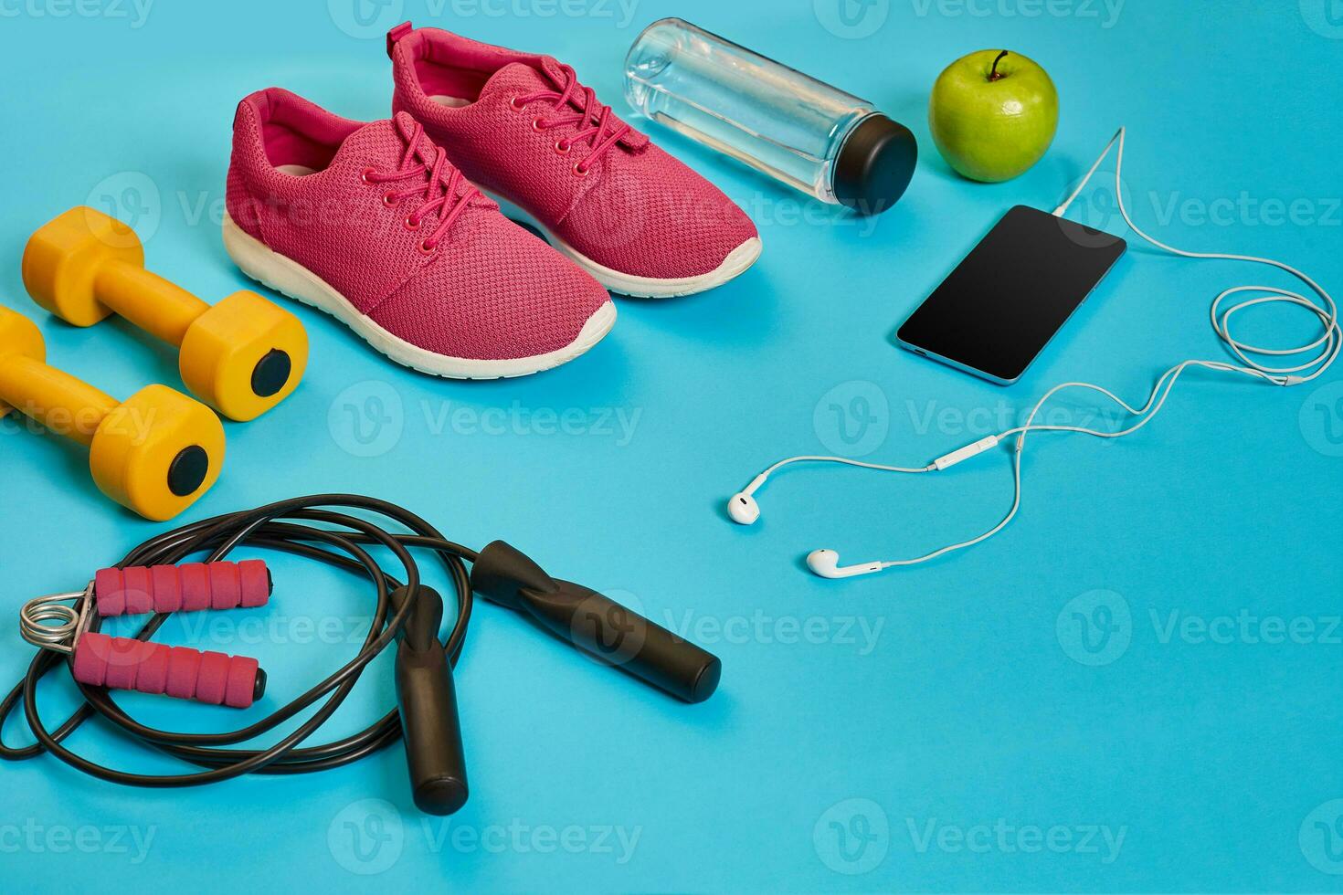 Flat lay of dumbbell, bottle of water, jump rope and sneaker, sport equipments, fitness items, top view photo