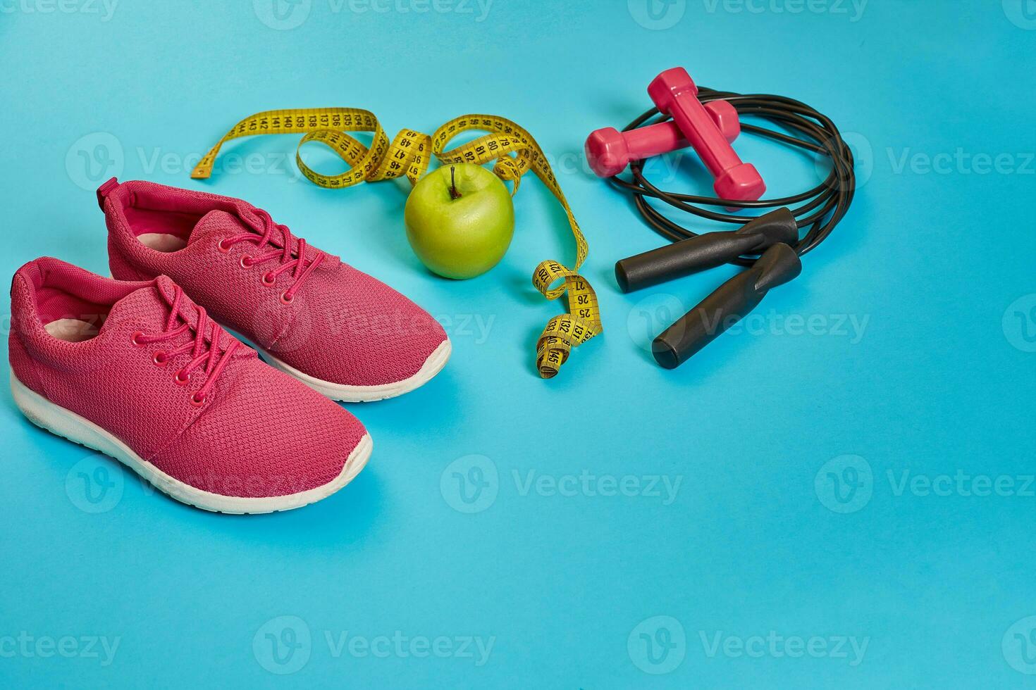 Flat lay of dumbbell, bottle of water, jump rope and sneaker, sport equipments, fitness items, top view photo