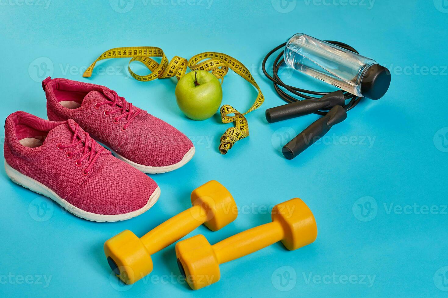 Flat lay of dumbbell, bottle of water, jump rope and sneaker, sport equipments, fitness items, top view photo
