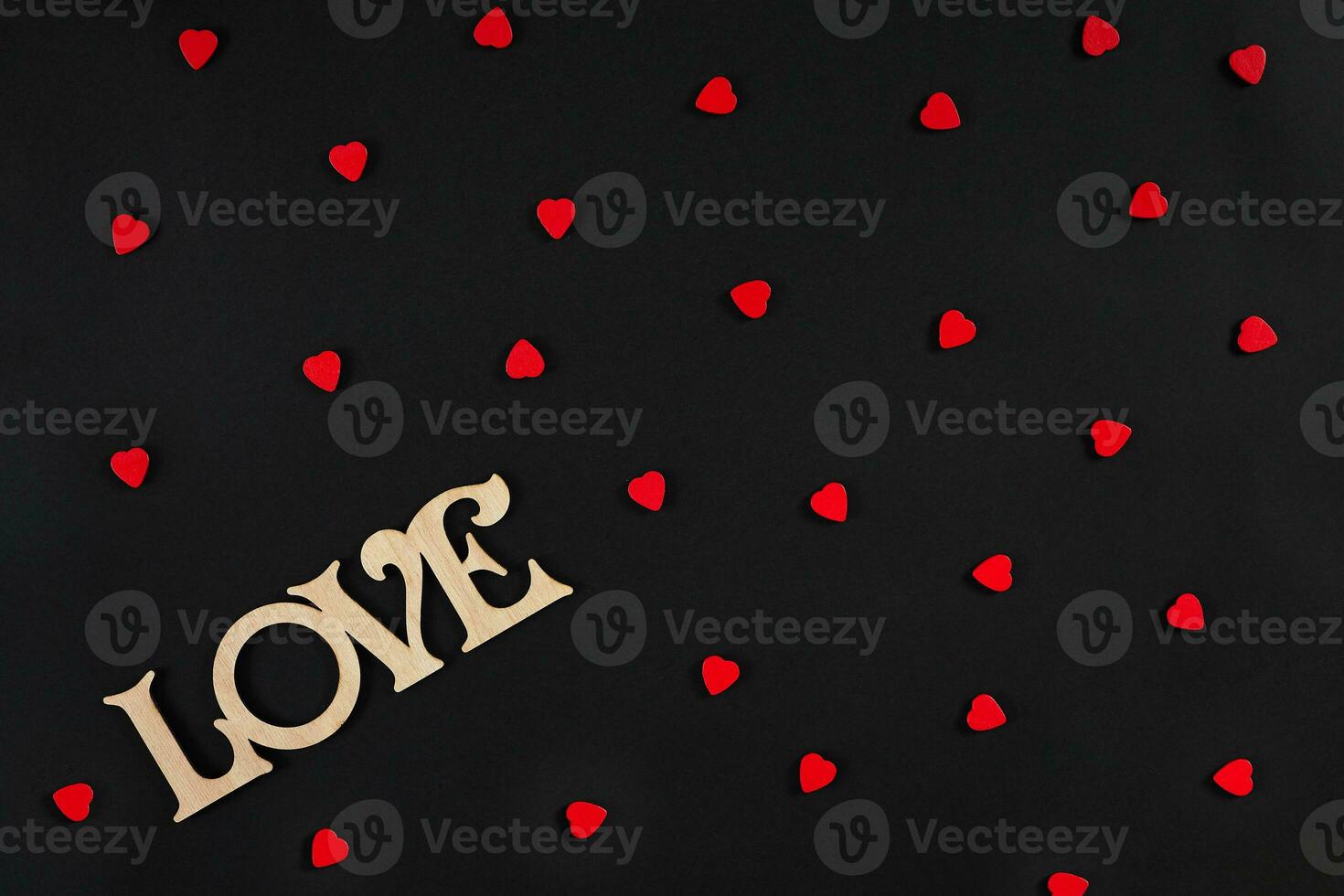 Valentines day background. Red hearts on the black desk photo