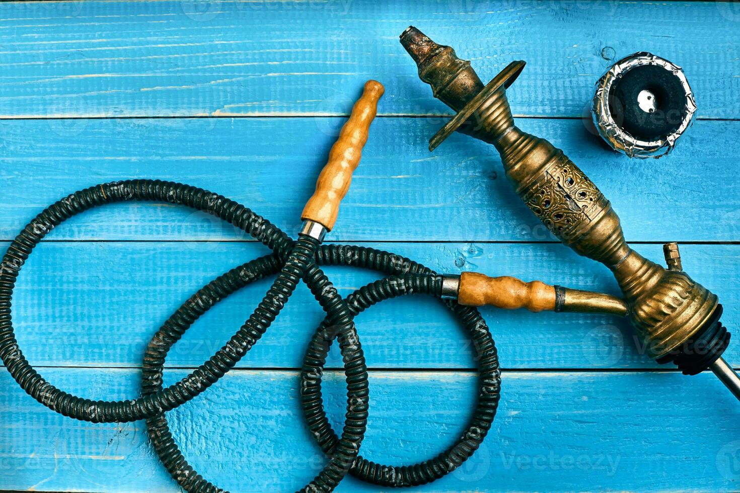 Parts of the hookah on blue wooden background. Hookah accessorie photo