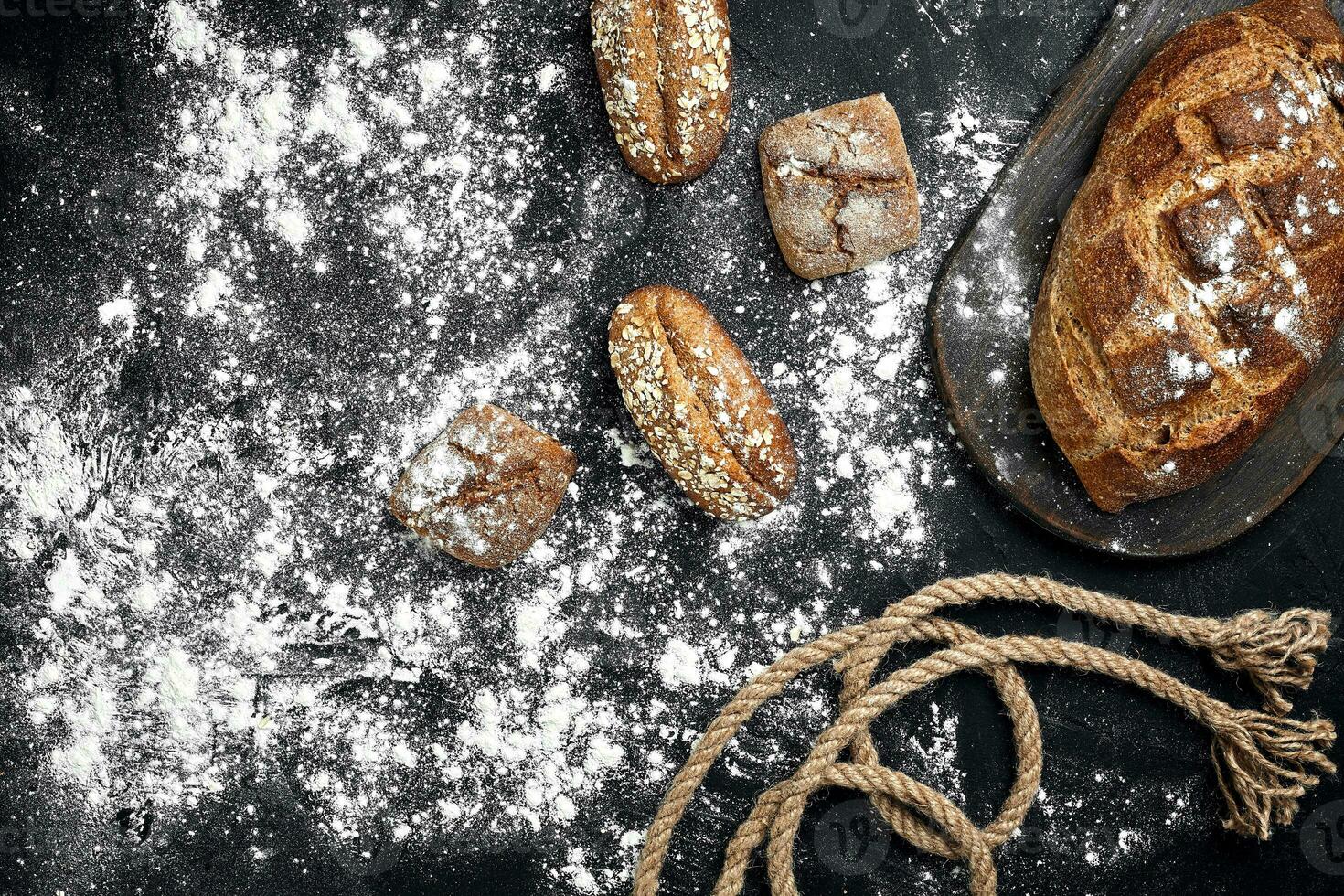 Mixed breads on black table. Top view with copy space. photo