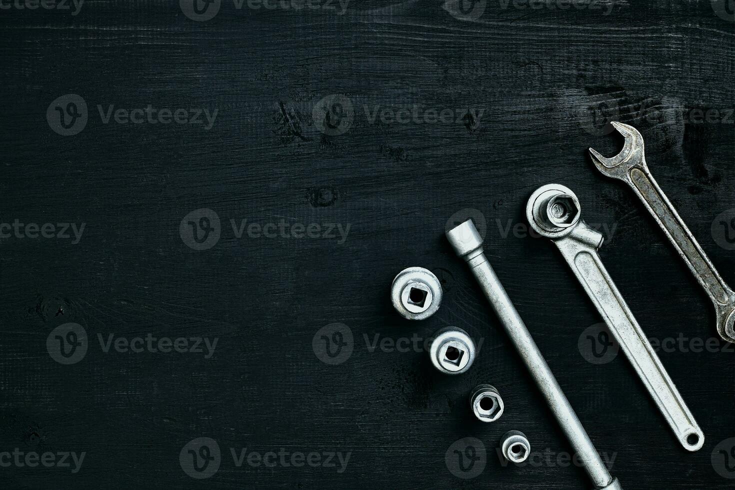 Tools for car repair in Workshop. Car repair equipment on black wooden background in car repair shop photo