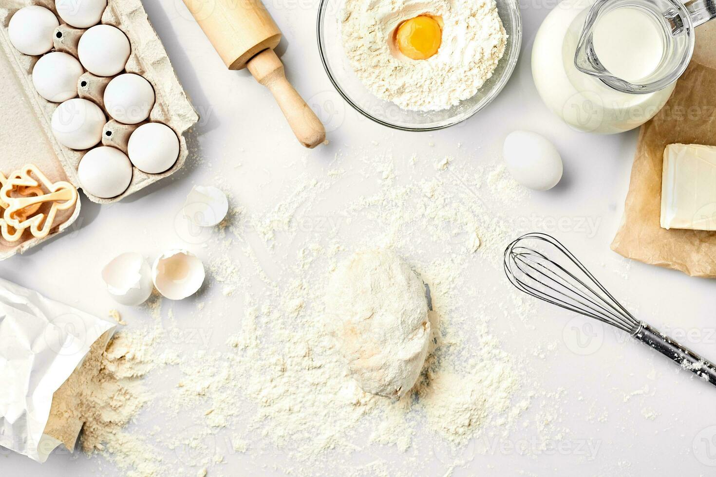 Raw dough ready for kneading on white table. Bakery ingredients, eggs, flour, butter. Shapes for making cookies. photo