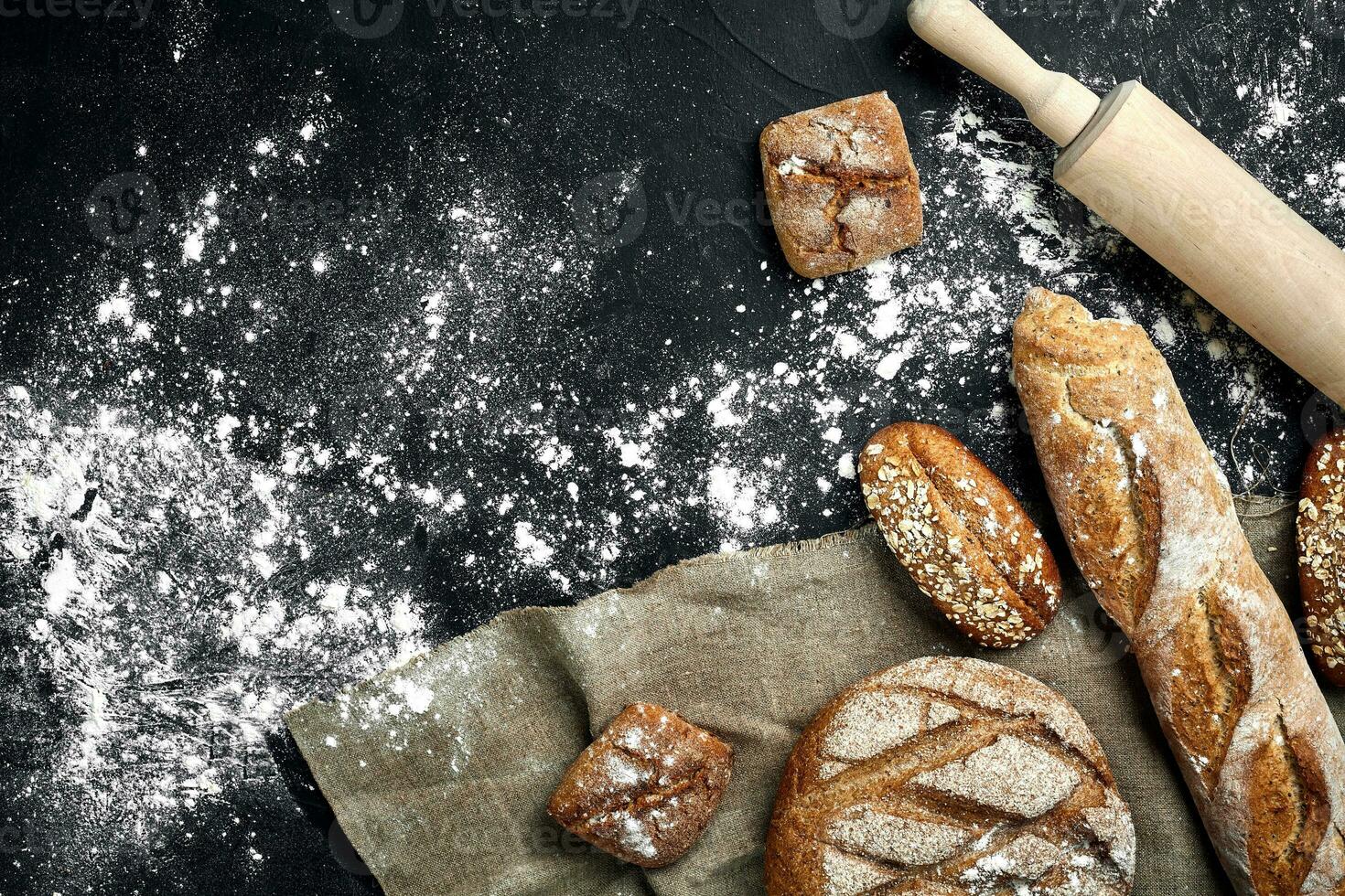 Mixed breads on black table. Top view with copy space. photo